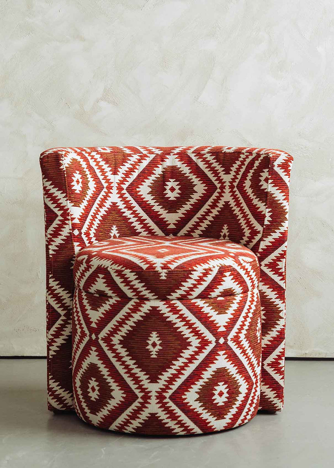 Butaca tapizada con tela de estampado geométrico rojo.