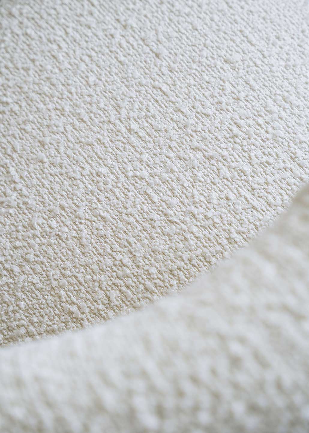 Silla de madera de haya tapizada en bouclé blanco con respaldo semicircular.