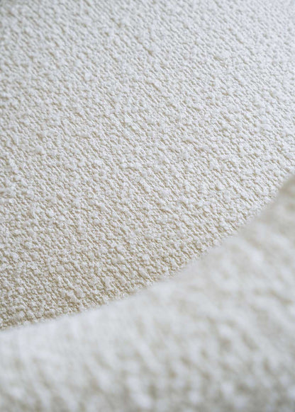 Silla de madera de haya tapizada en bouclé blanco con respaldo semicircular.