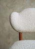 Silla de madera de haya tapizada en bouclé blanco.