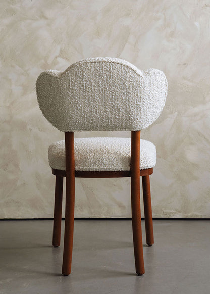 Silla de madera de haya tapizada en bouclé blanco.