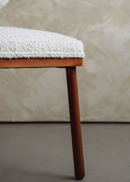 Silla de madera de haya tapizada en bouclé blanco.