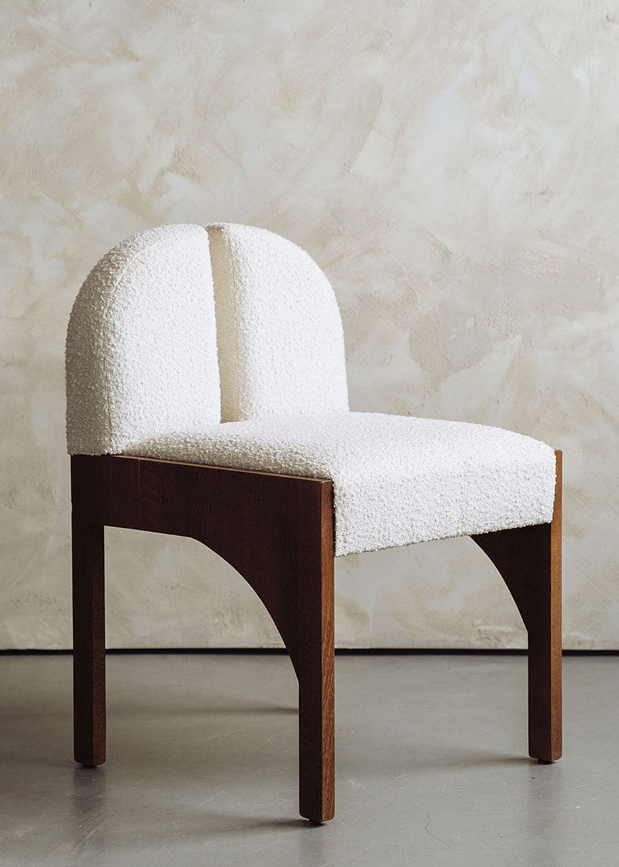 Silla de madera de haya tapizada en bouclé blanco.