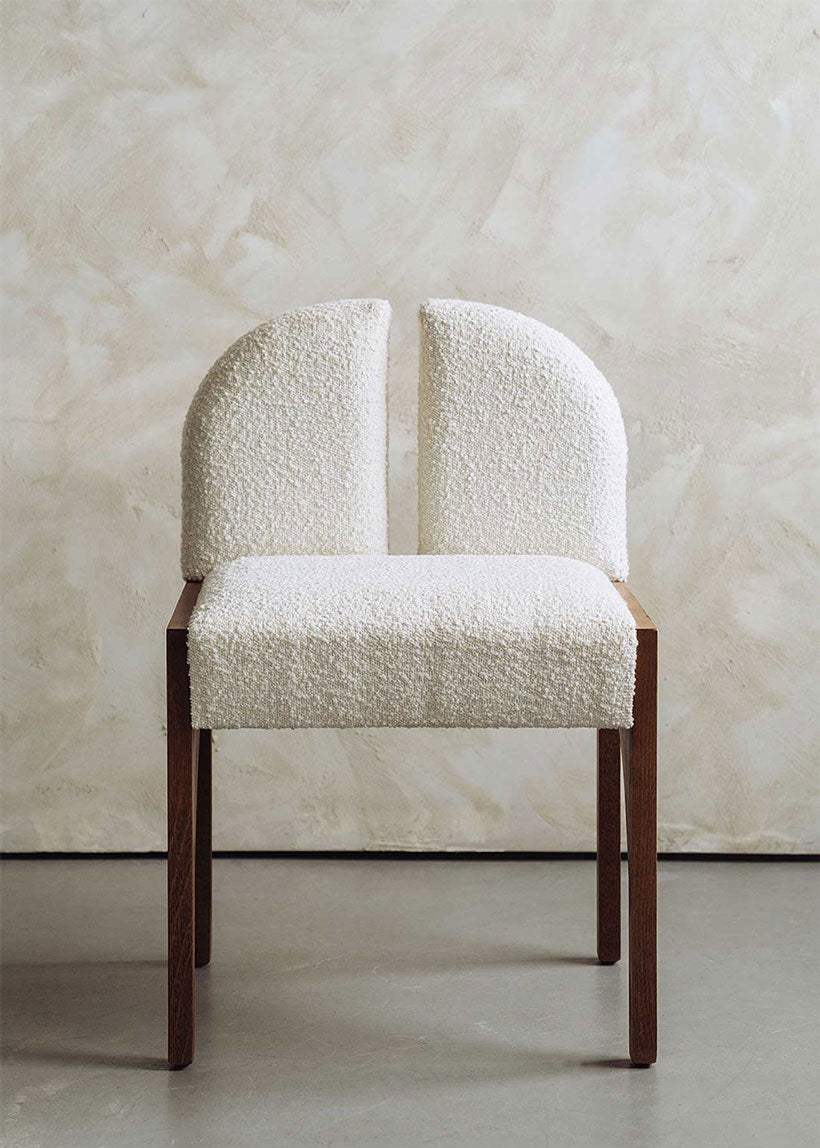 Silla de madera de haya tapizada en bouclé blanco.