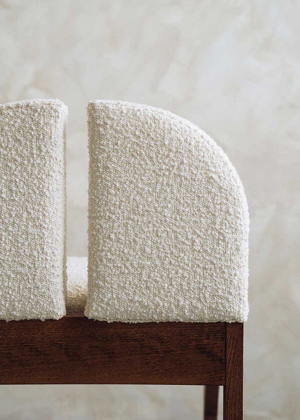 Silla de madera de haya tapizada en bouclé blanco.
