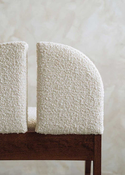 Silla de madera de haya tapizada en bouclé blanco.