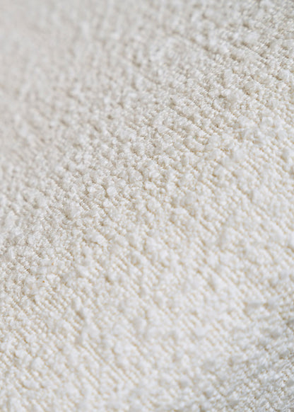 Silla de madera de haya tapizada en bouclé blanco.