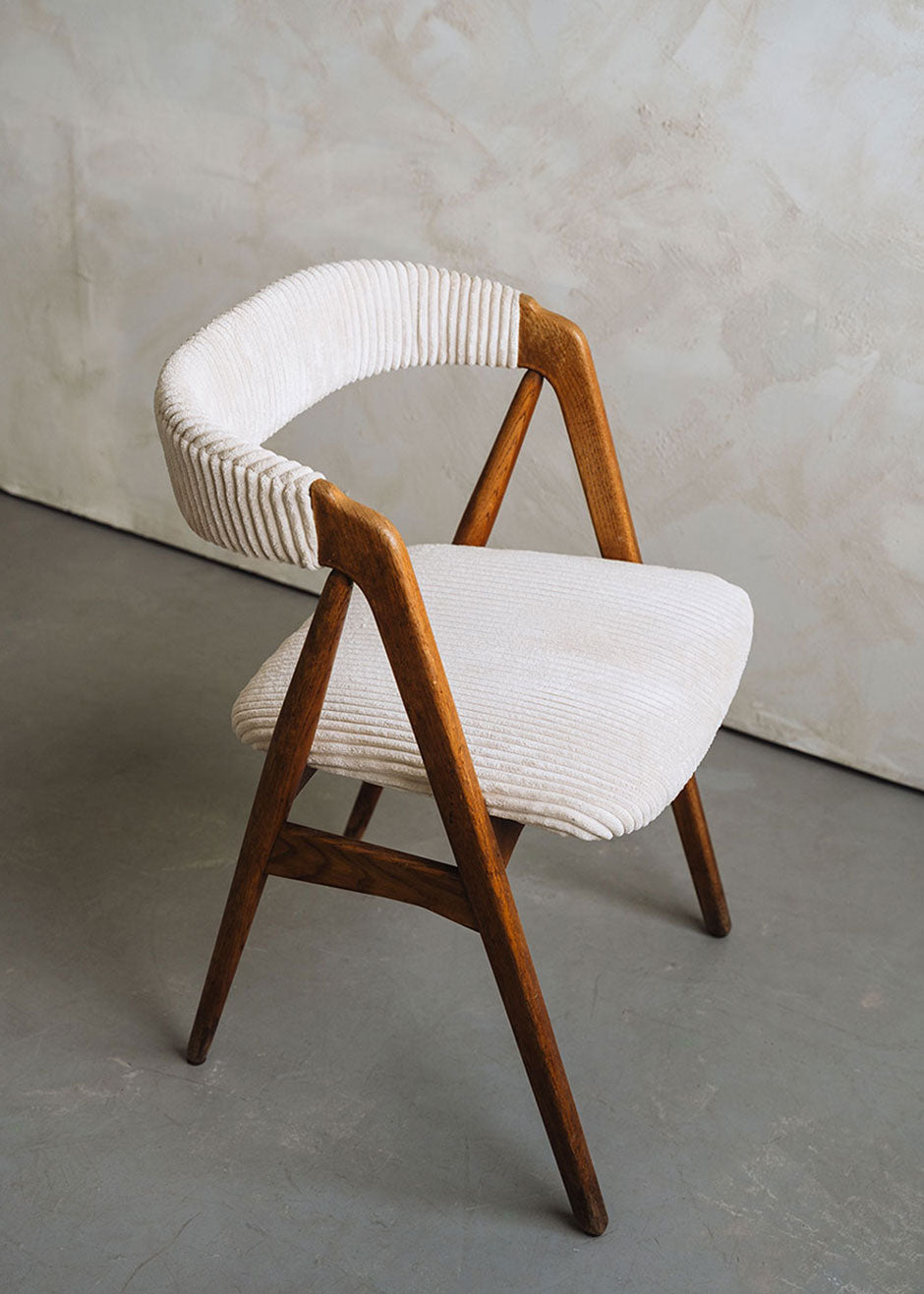 Silla de madera de haya tapizada en pana beige.