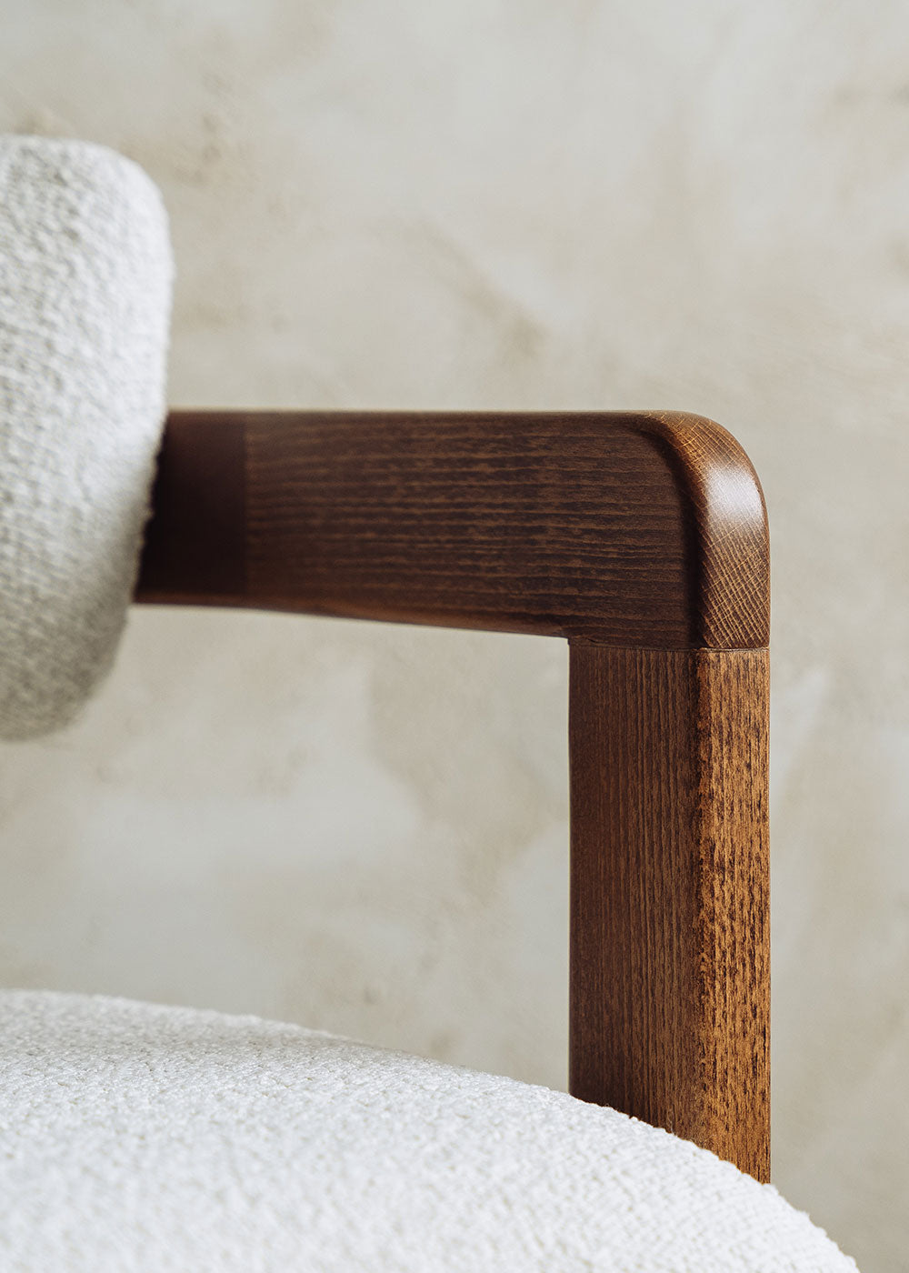 Silla de madera de haya con reposabrazos tapizada en terciopelo beige.