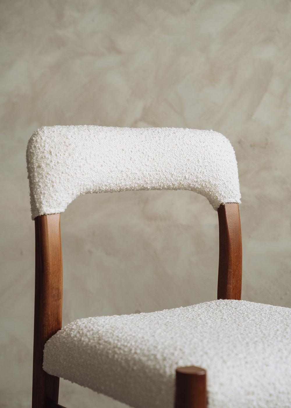 Silla de madera de haya tapizada en bouclé blanco.