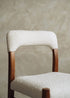 Silla de madera de haya tapizada en bouclé blanco.