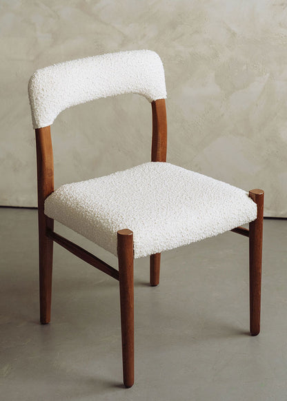 Silla de madera de haya tapizada en bouclé blanco.