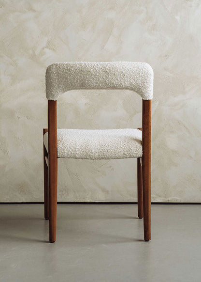 Silla de madera de haya tapizada en bouclé blanco.