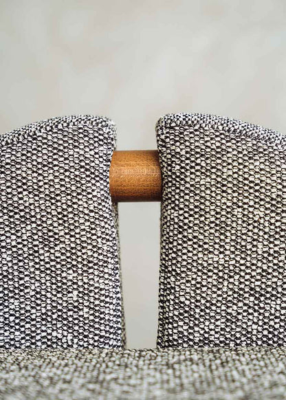 Taburete tapizado en tela jaspeada blanca y negra con estructura de madera de haya. Un taburete alto con respaldo y reposapiés incorporado.