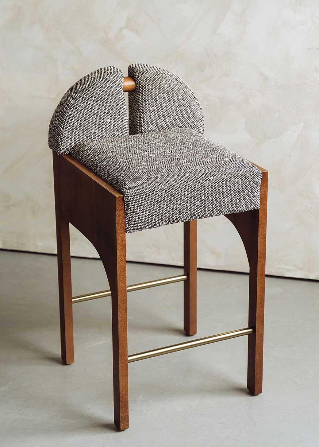 Taburete tapizado en tela jaspeada blanca y negra con estructura de madera de haya. Un taburete alto con respaldo y reposapiés incorporado.