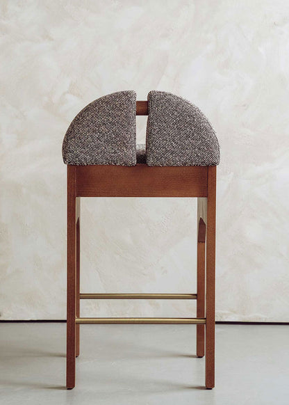 Taburete tapizado en tela jaspeada blanca y negra con estructura de madera de haya. Un taburete alto con respaldo y reposapiés incorporado.