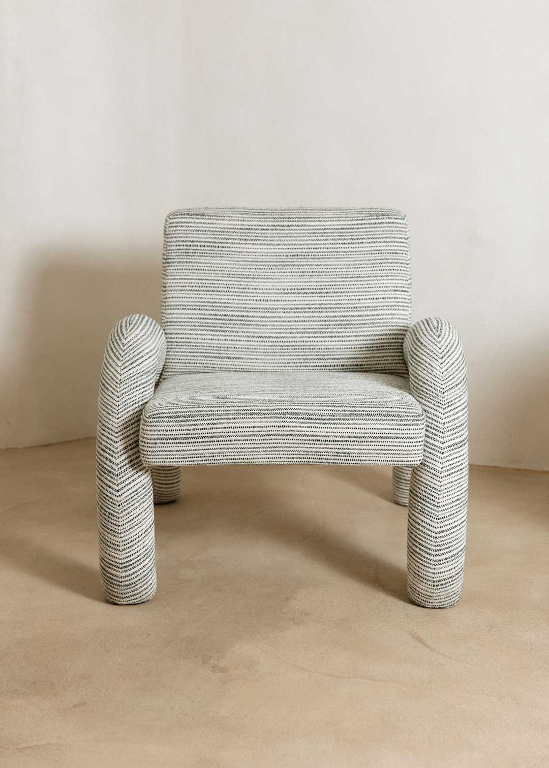 Butaca con reposabrazos tapizado con tela rayada azul y blanca.