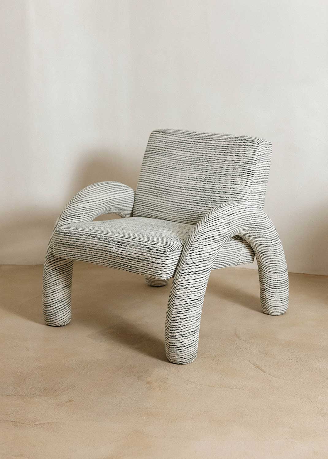 Butaca con reposabrazos tapizado con tela rayada azul y blanca.