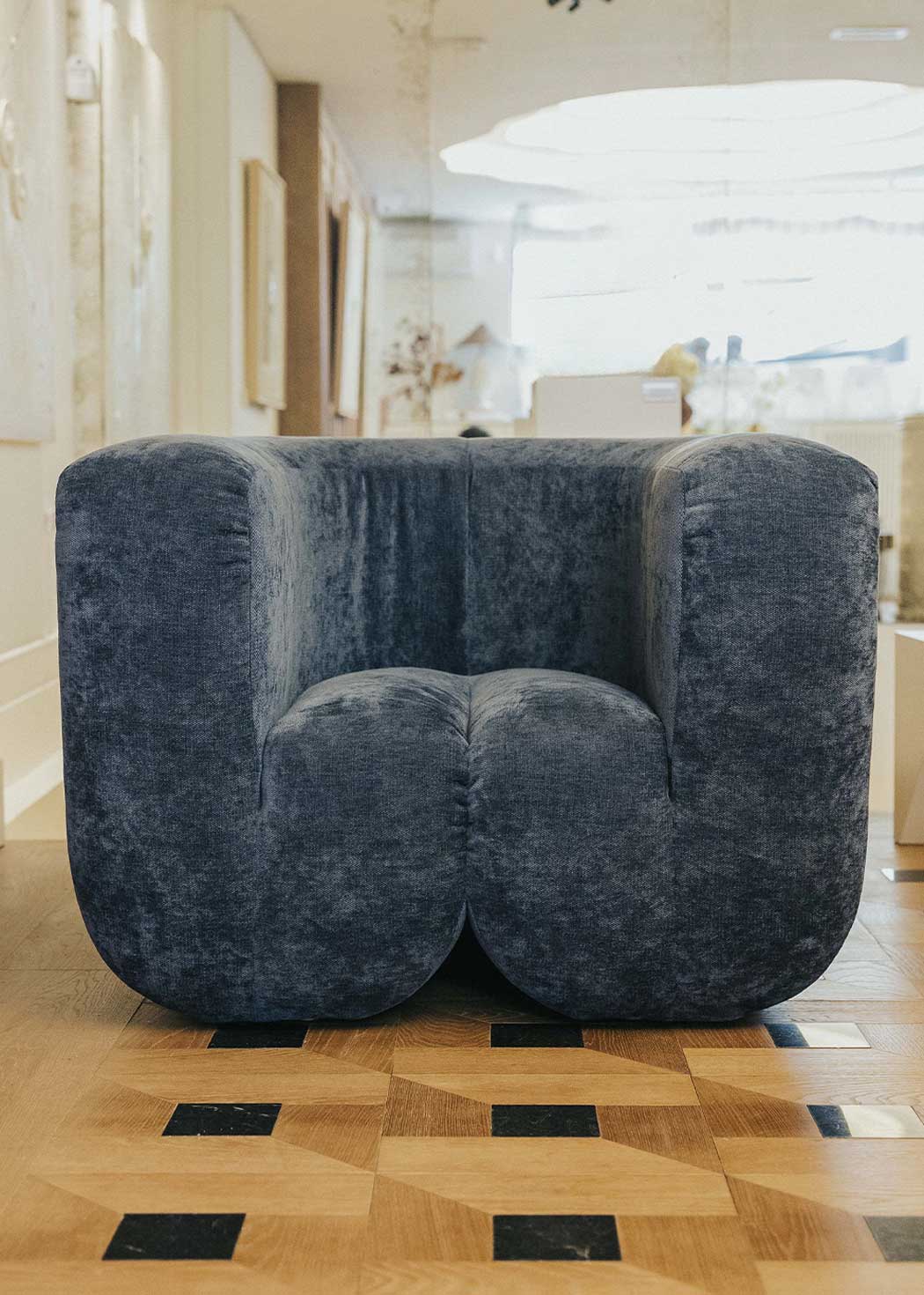 Sillón tapizado con tela de chenilla azul.