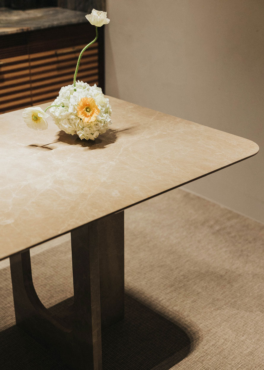 Mesa de comedor rectangular con pies en forma de cruz realizada en mármol Emperador claro pulido.