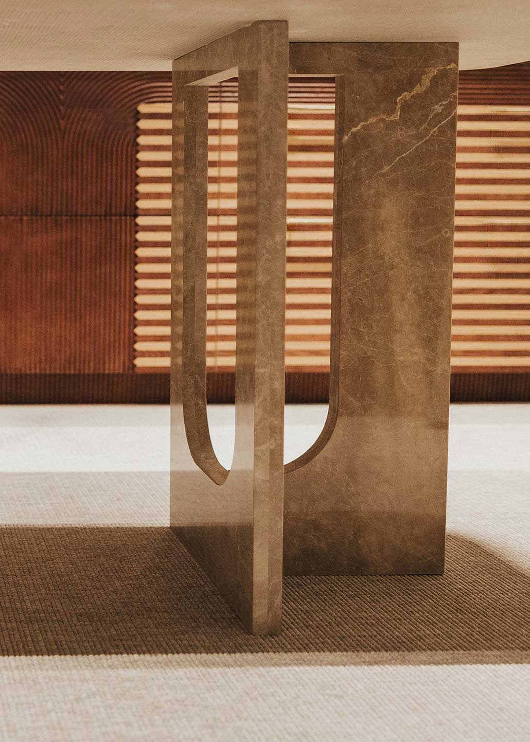 Mesa de comedor rectangular con pies en forma de cruz realizada en mármol Emperador claro pulido.