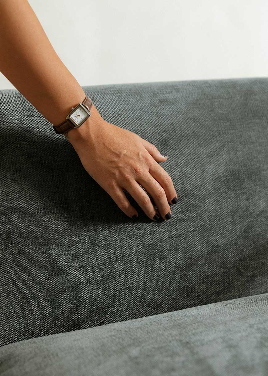 Butaca con reposabrazos tapizado con tela de chenilla azul.