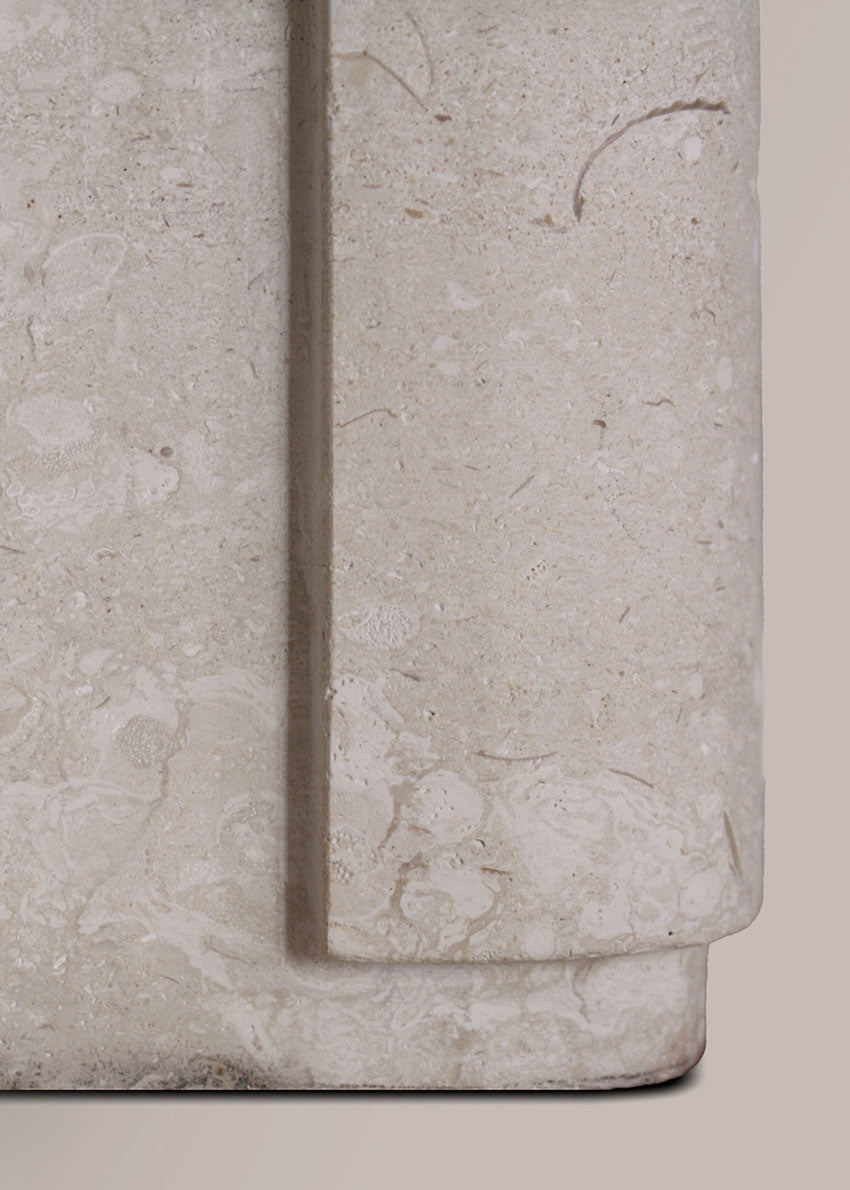 Lámpara de mesa con base escultórica realizada en un único bloque de piedra caliza tallado.