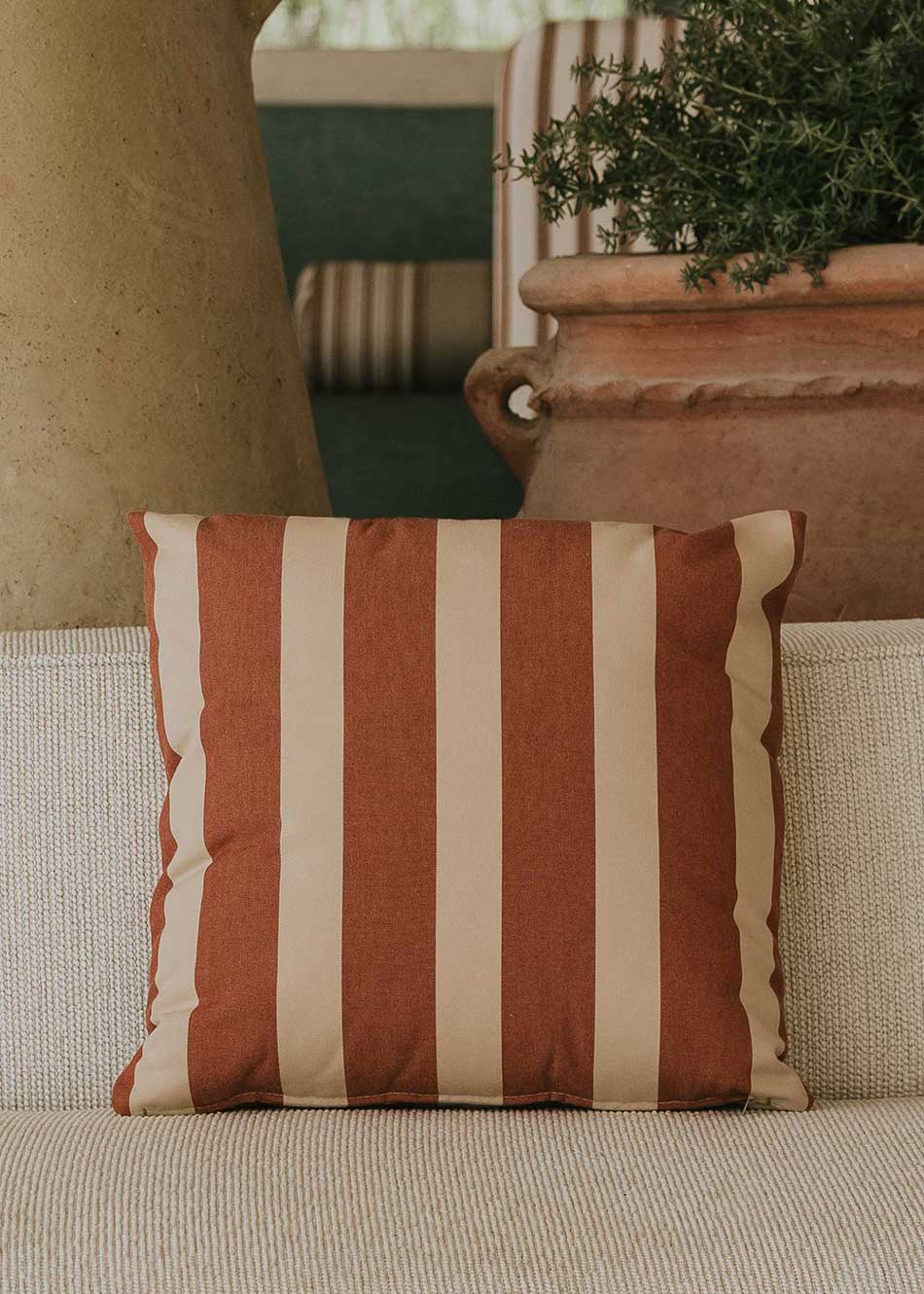 Almohadón cuadrado con estampado de rayas beige y teja.