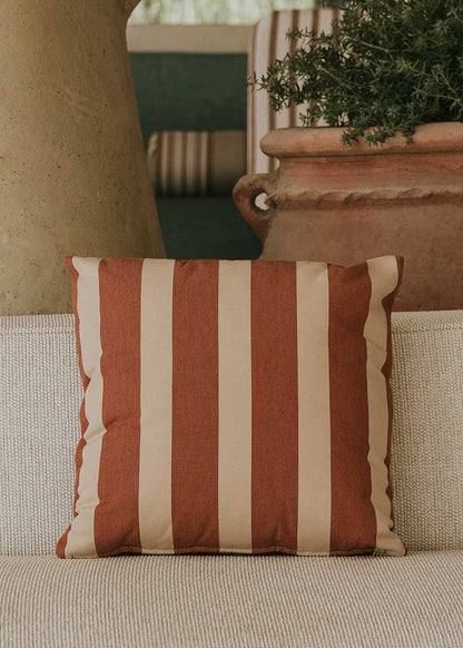 Almohadón cuadrado con estampado de rayas beige y teja.