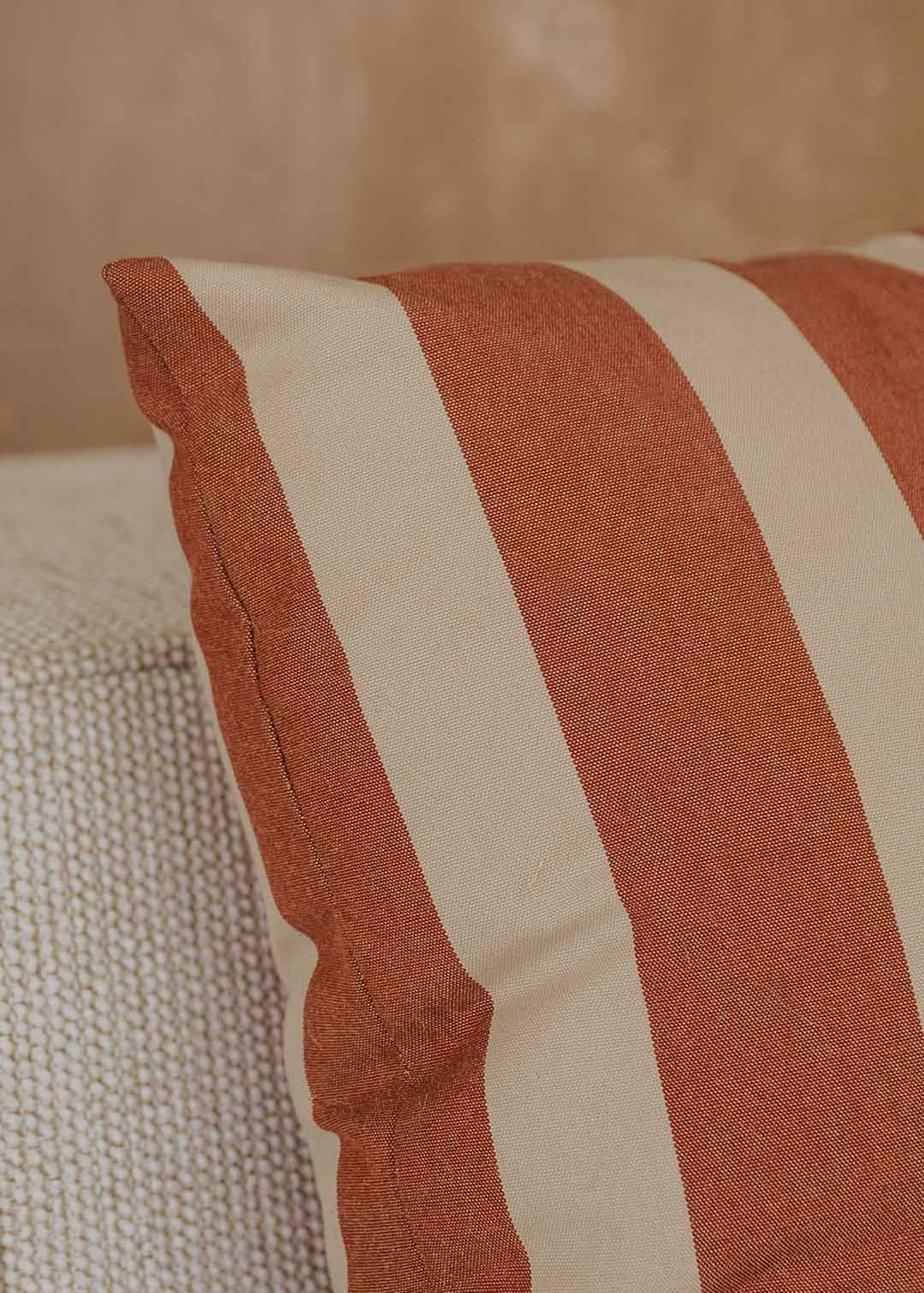 Almohadón cuadrado con estampado de rayas beige y teja.