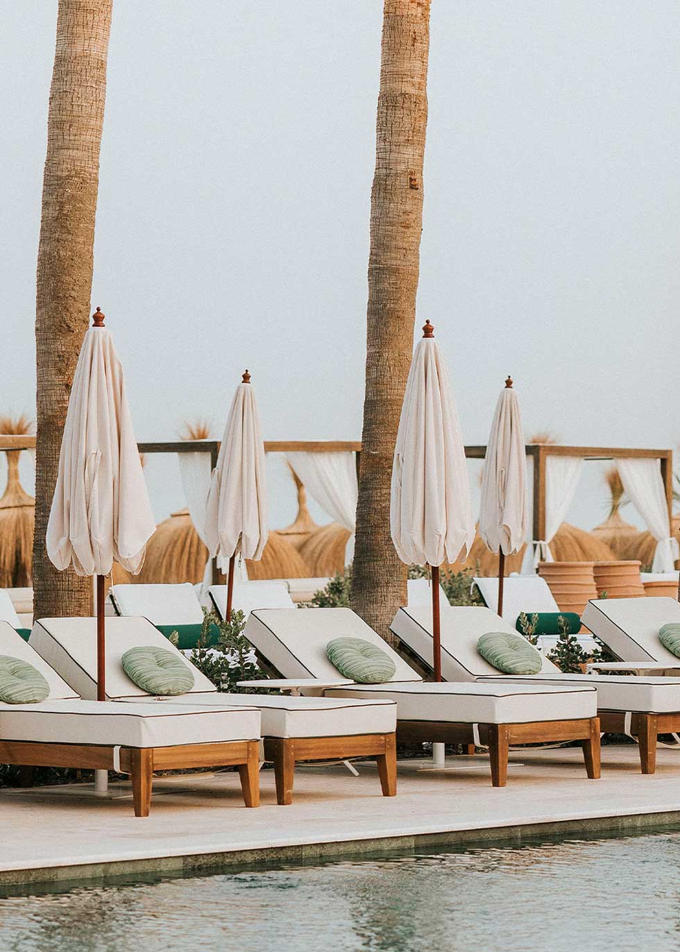 Hamaca de madera natural cerejeira con colchoneta tapizada en tela blanca y vivo en verde.