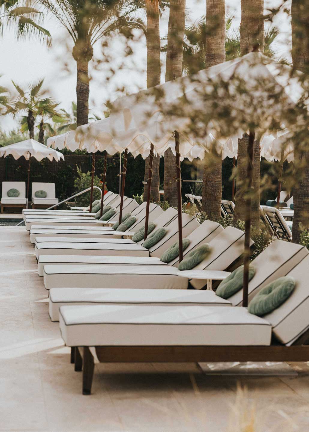 Hamaca de madera natural cerejeira con colchoneta tapizada en tela blanca y vivo en verde.