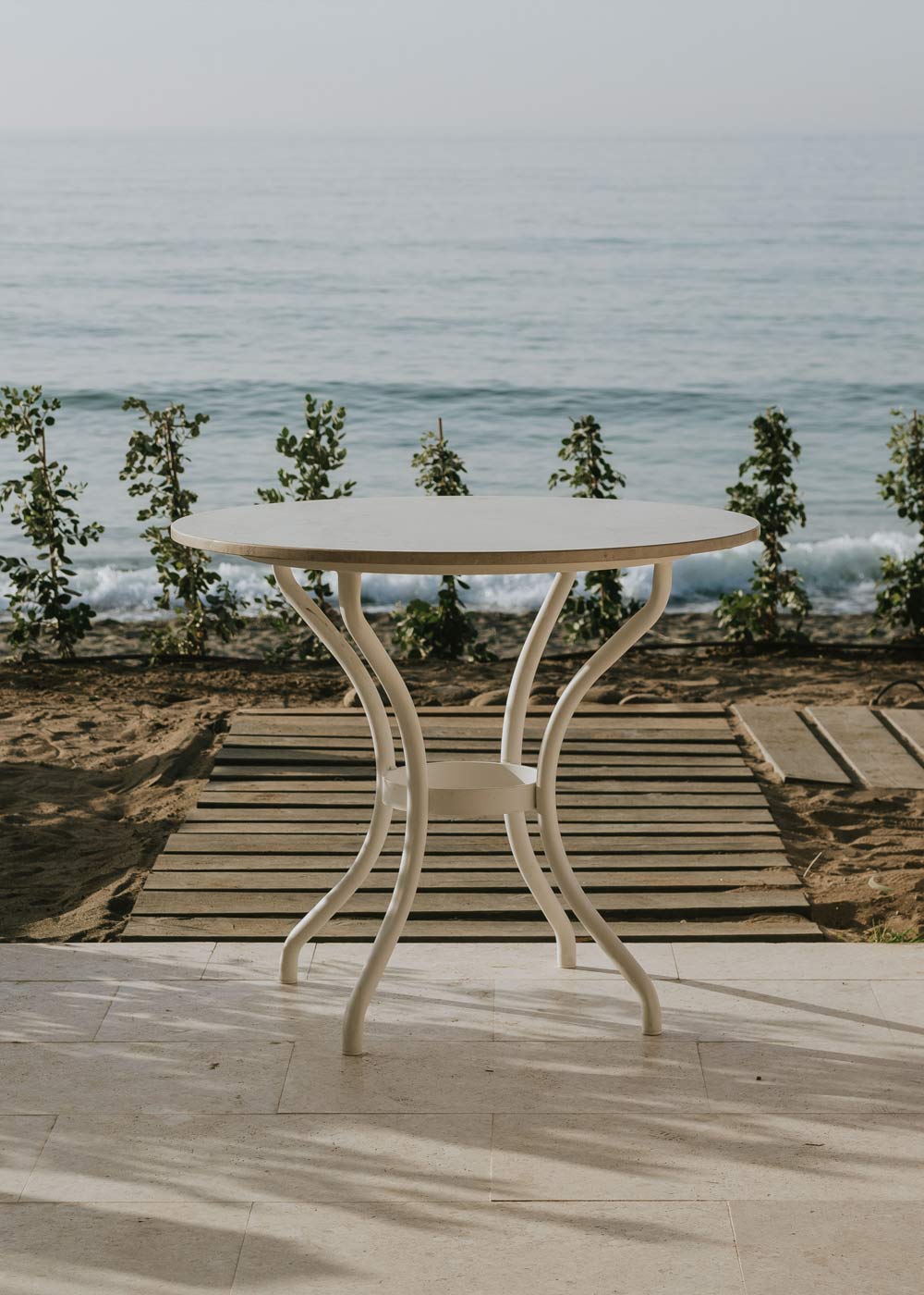 Mesa de exterior circular con estructura de hierro y caliza