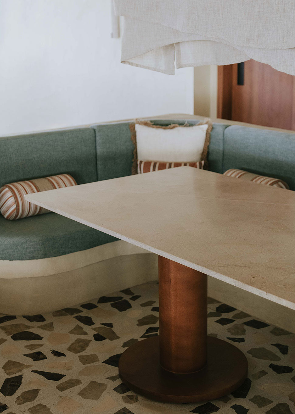 Mesa de comedor rectangular con sobre de mármol crema marfil y pies en madera de haya barnizados.