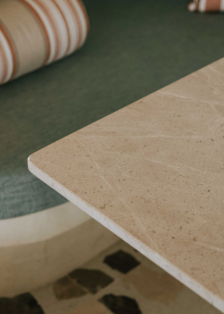 Mesa de comedor rectangular con sobre de mármol crema marfil y pies en madera de haya barnizados.