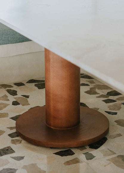 Mesa de comedor rectangular con sobre de mármol crema marfil y pies en madera de haya barnizados.