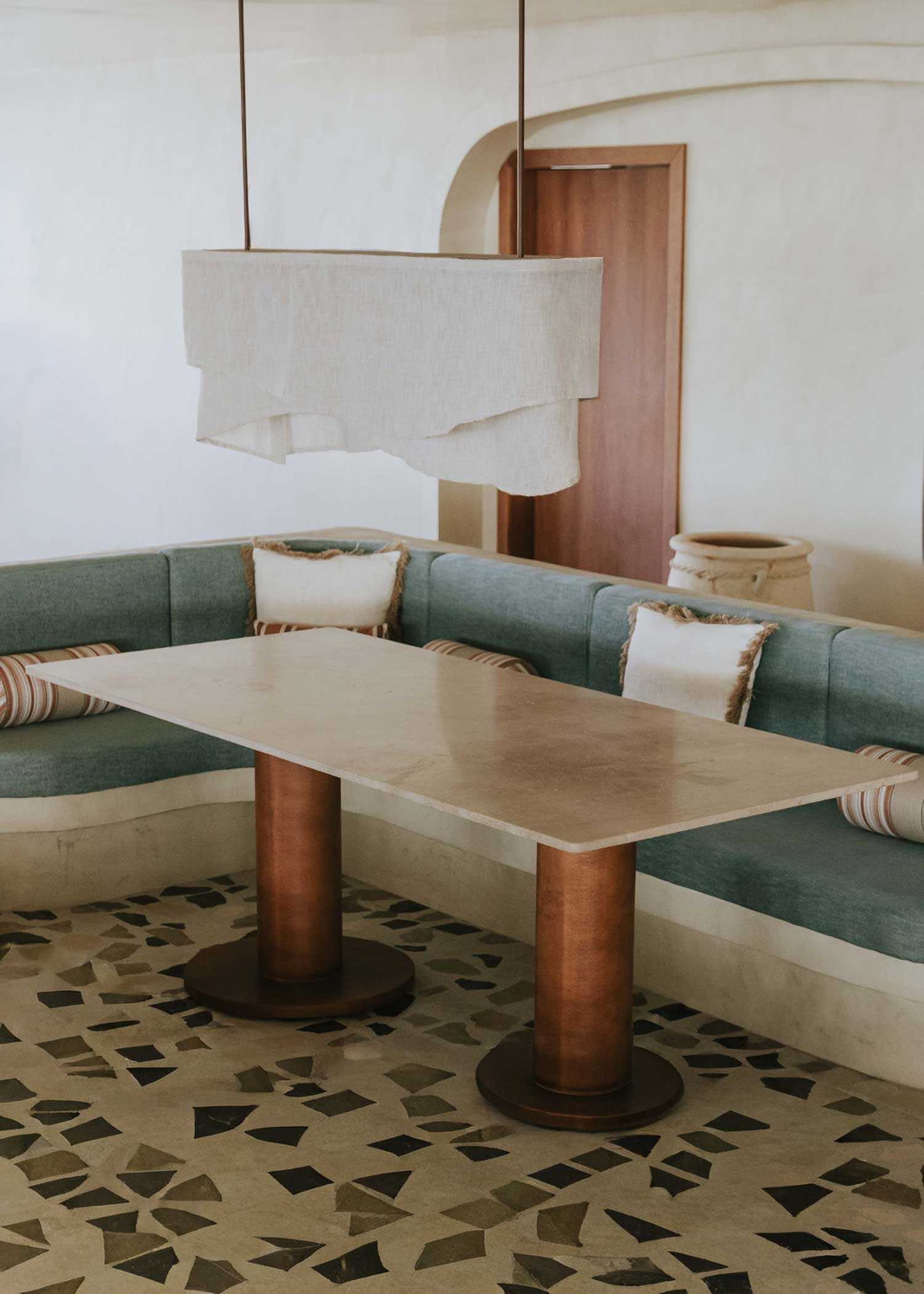 Mesa de comedor rectangular con sobre de mármol crema marfil y pies en madera de haya barnizados.