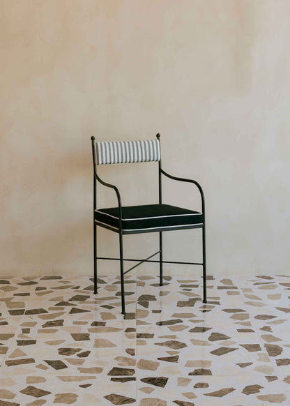 Silla de exterior con estructura de hierro negro tapizada en gris, negro y blanco.