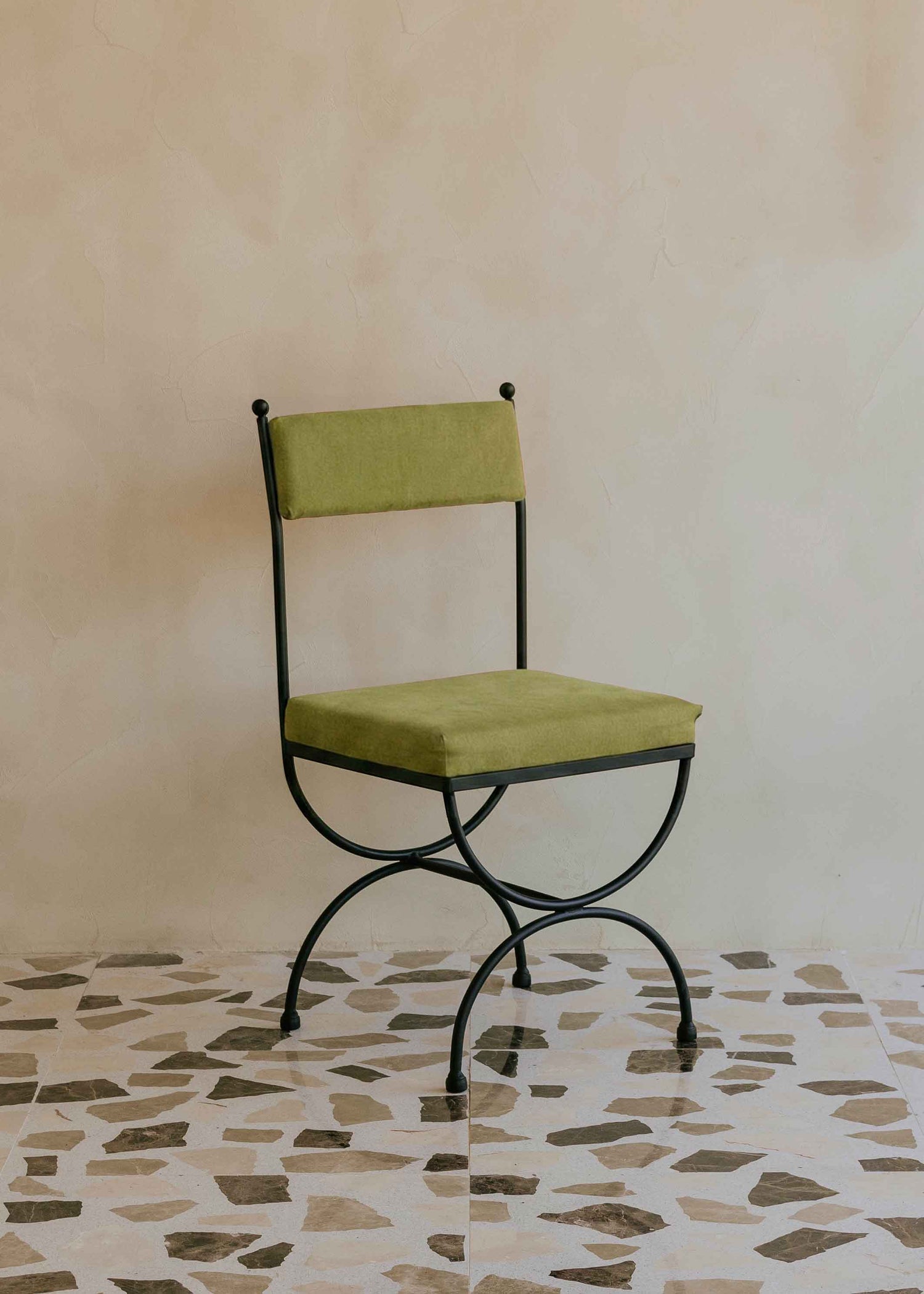 Silla de exterior con estructura de hierro negro tapizada en color pistacho