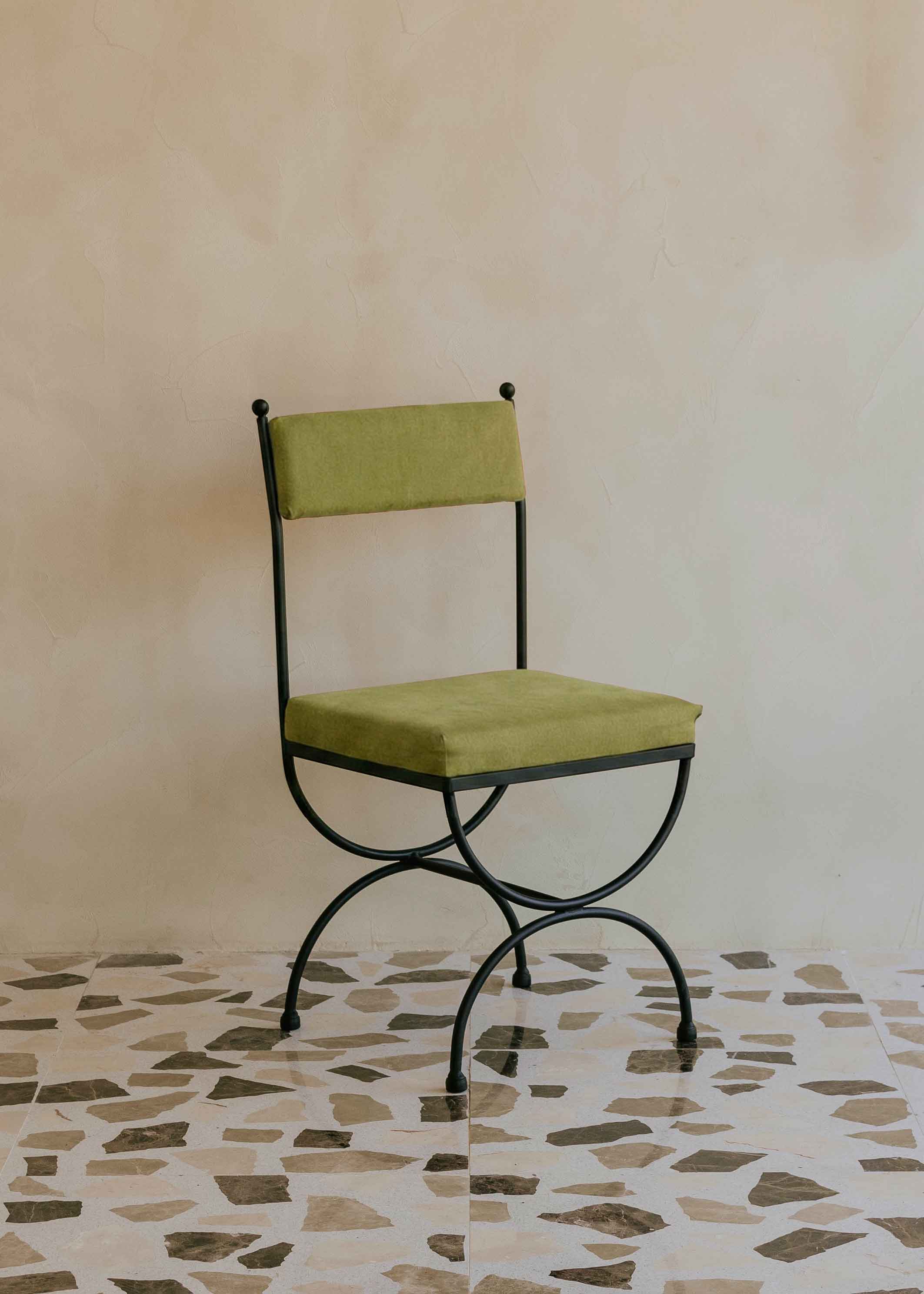 Silla de exterior con estructura de hierro negro tapizada en color pistacho