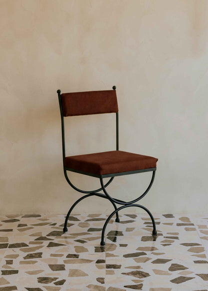 Silla de exterior con estructura de hierro negro tapizada en color óxido.