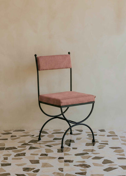 Silla de exterior con estructura de hierro negro tapizada en color rosa empolvado