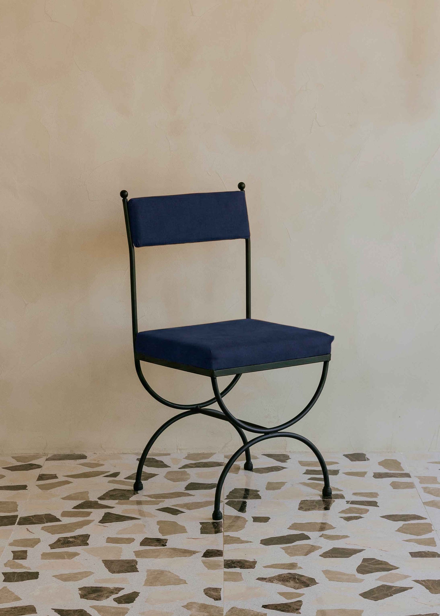 Silla de exterior con estructura de hierro negro tapizada en color azul marino