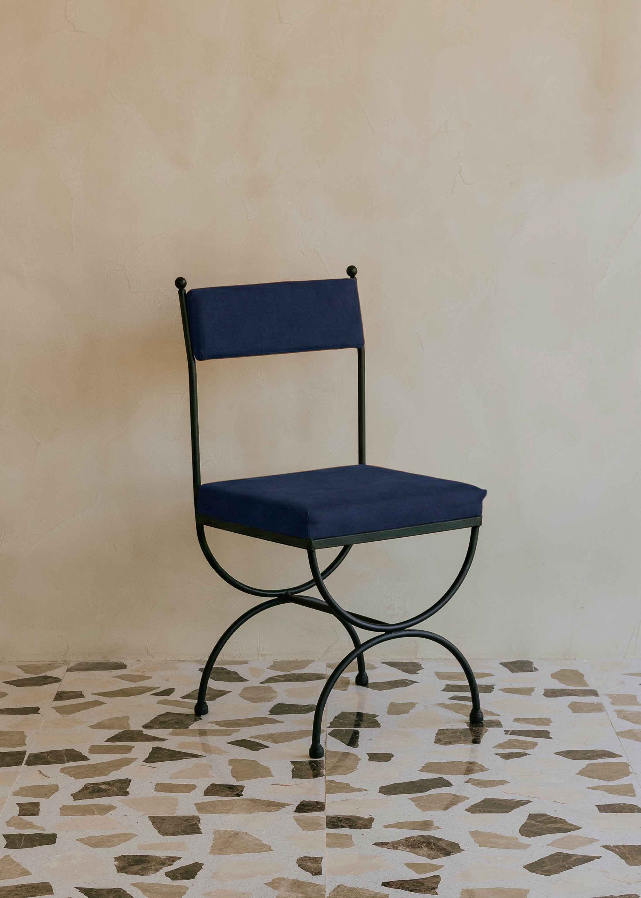 Silla de exterior con estructura de hierro negro tapizada en color azul marino
