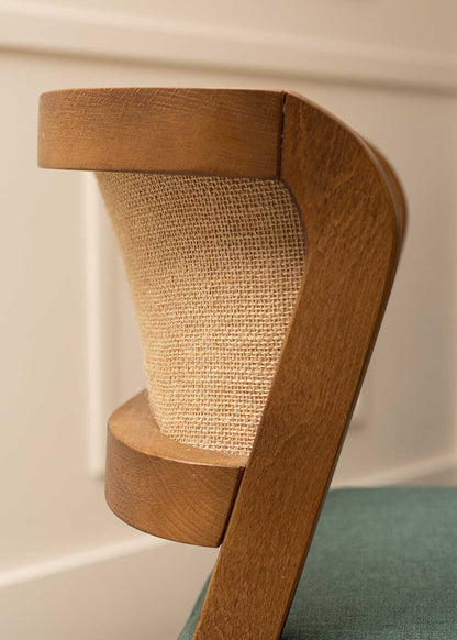 Silla de madera de haya tapizada con terciopelo verde y respaldo de tela de yute.
