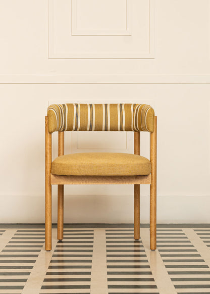 Silla de madera de haya con reposabrazos, asiento tapizado en tela mostaza y respaldo con estampado de rayas.
