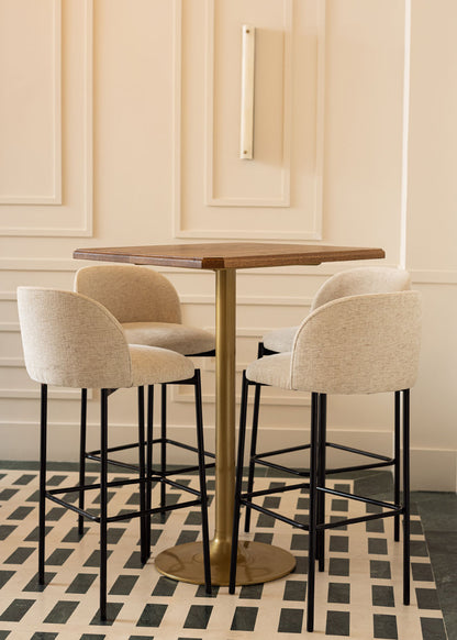 Taburete tapizado en tela beige con estructura de hierro acabado en negro