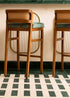 Taburete con estructura de madera de haya tapizado en terciopelo verde con respaldo de tela de yute