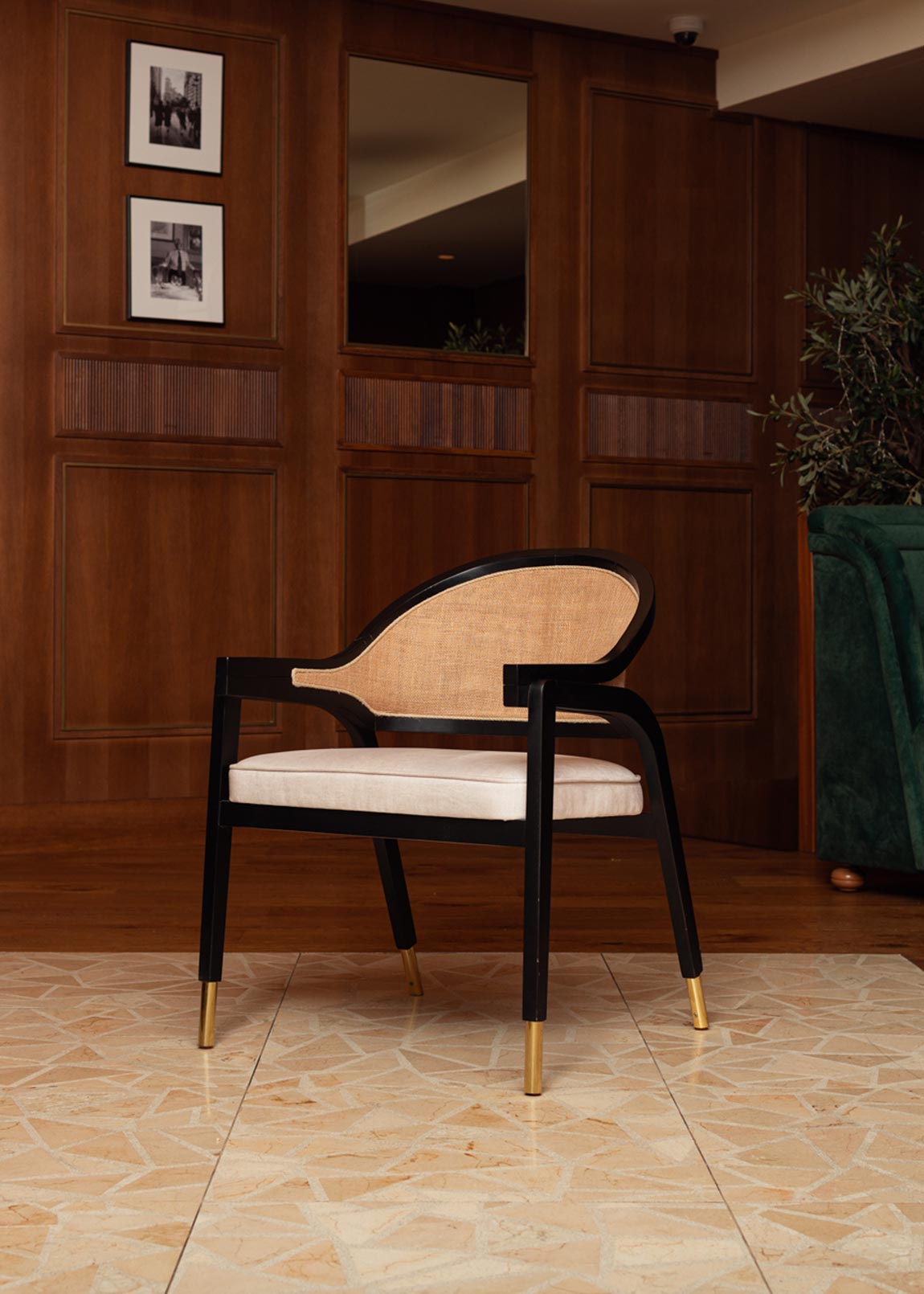 Silla de madera negra, tapizada con terciopelo beige y con respaldo de rafia