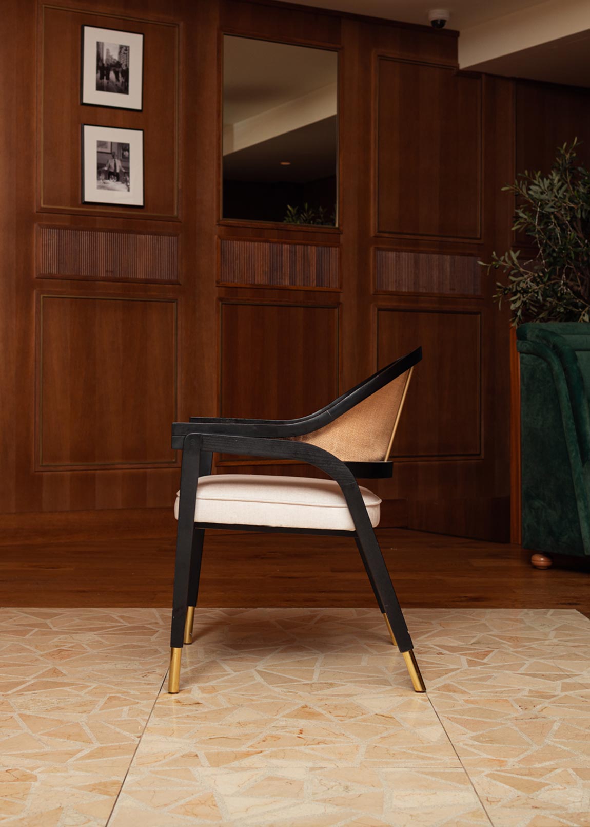 Silla de madera negra, tapizada con terciopelo beige y con respaldo de rafia